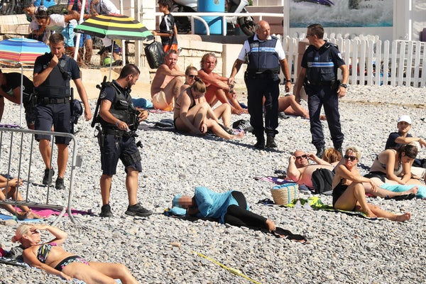 Police fine the first person for wearing a burkini on the Promenade des Anglais beach in Nice, France on August 23, 2016. The