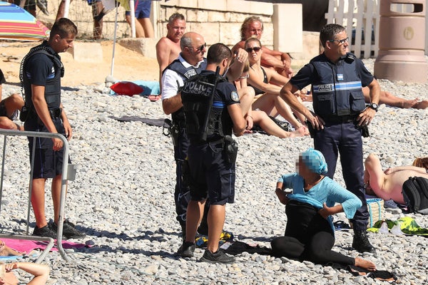 Police fine the first person for wearing a burkini on the Promenade des Anglais beach in Nice, France on August 23, 2016. The