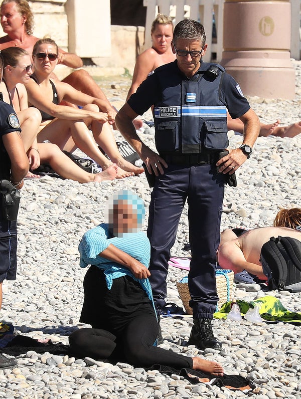 Police fine the first person for wearing a burkini on the Promenade des Anglais beach in Nice, France on August 23, 2016. The