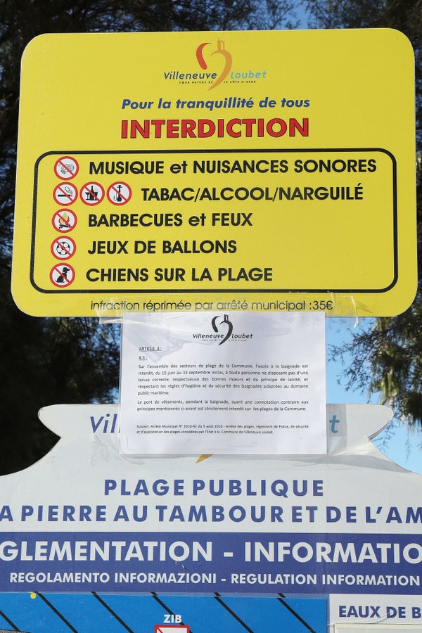 Police fine the first person for wearing a burkini on the Promenade des Anglais beach in Nice, France on August 23, 2016. The