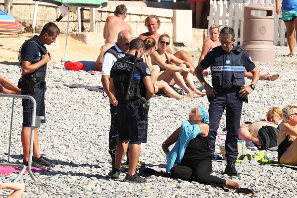Police fine the first person for wearing a burkini on the Promenade des Anglais beach in Nice, France on August 23, 2016. The