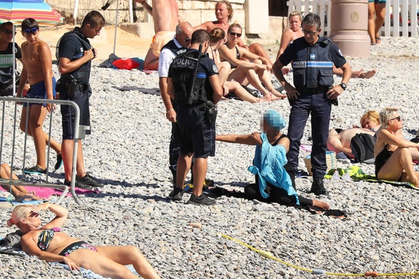 Police fine the first person for wearing a burkini on the Promenade des Anglais beach in Nice, France on August 23, 2016. The