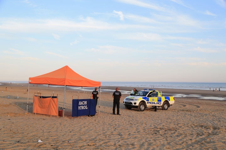 Police officers at the scene in Camber Sands, near Rye, East Sussex 