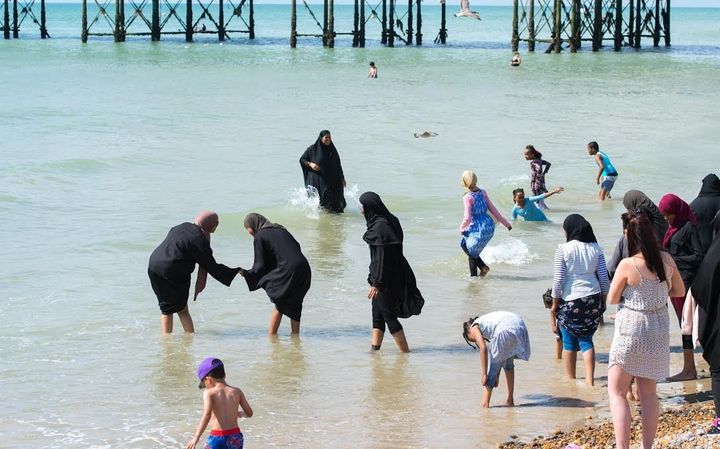 Burka-clad women enjoying a paddle at Brighton beach on Wednesday
