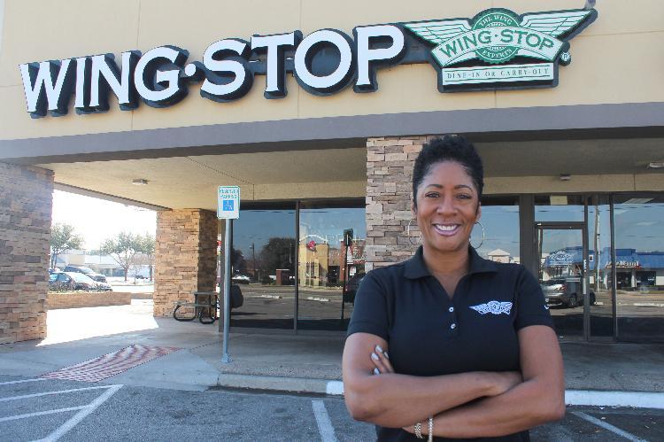 Howell poses in front of one of her Miami-based Wingstop franchises.