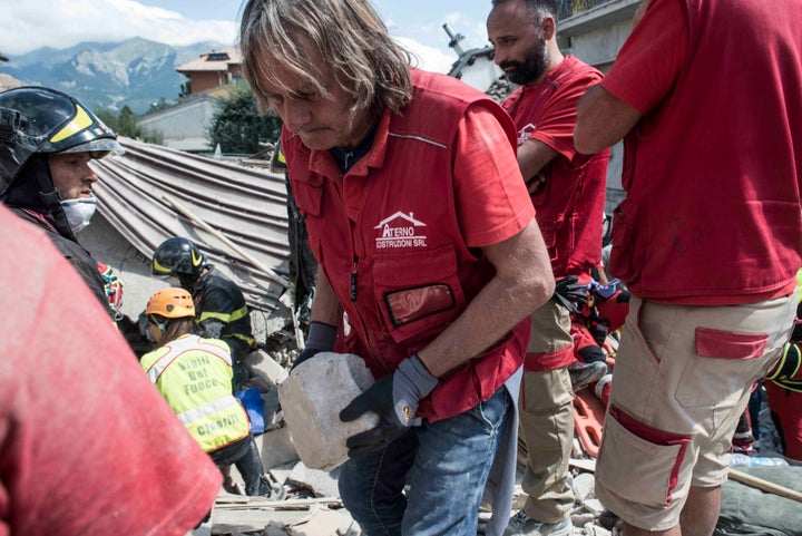 A volunteer helps rescuers search for victims in damaged buildings after a strong earthquake hit Amatrice on August 24, 2016.