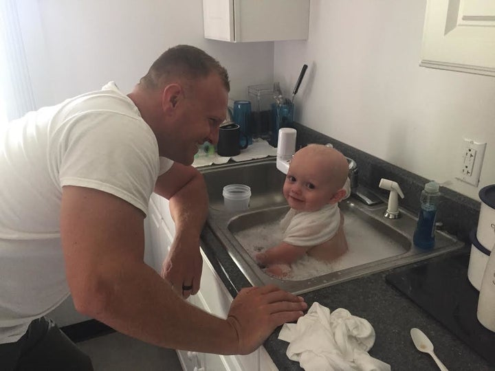 A West Virginia State trooper is seen bathing a baby who was found in an alleged DUI driver's vehicle on Tuesday.