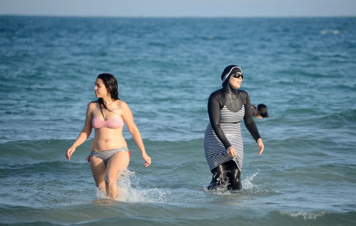 Tunisian women, one wearing a "burkini," a full-body swimsuit designed for Muslim women, swim on Aug. 16, 2016, at Ghar El Melh beach near Bizerte, northeast of the capital Tunis.