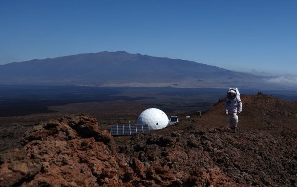 A HI-SEAS scientist atop a ridge above the habitat.