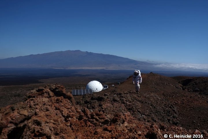 A HI-SEAS scientist atop a ridge above the habitat.