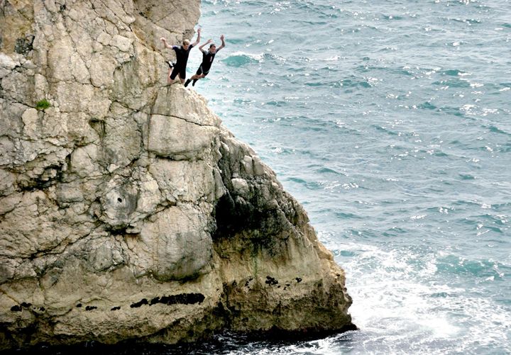 <strong>Two men jump off rocks into the sea at Durdle Door near West Lulworth, Dorset.</strong>