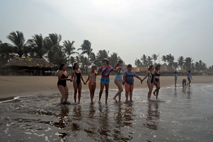 Nieva guides the girls into the sea at Puerto Arista beach in Chiapas.