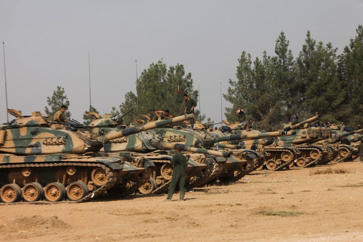 Turkish soldiers stand on tanks as they prepare for a military operation at the Syrian border town of Karkamis in the souther