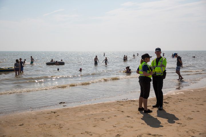 A search is underway at Camber Sands for a missing woman days after five men died at the East Sussex beach; police are pictured above at the beach following Wednesday's tragedy 