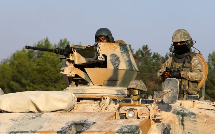 Turkish soldiers on an armoured personnel carrier drive towards the border in Karkamis on the Turkish-Syrian border in the so