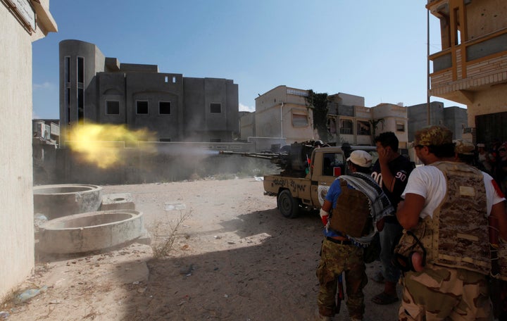 embers of Libyan forces allied with the UN-backed government fire a weapon towards Islamic State militants in neighbourhood N