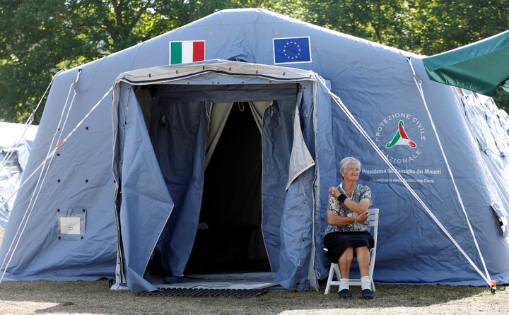 A woman sits outside a tent camp set up as a temporary shelter following an earthquake in Amatrice, central Italy.