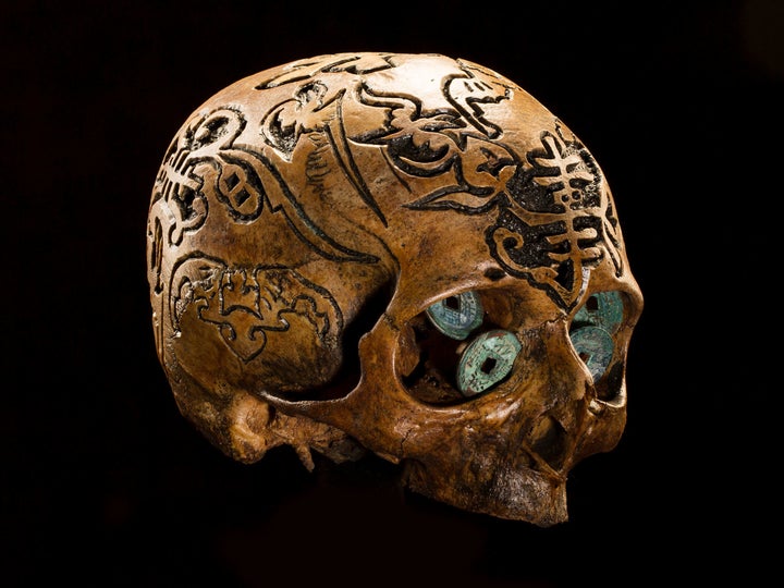 <strong>Wealth of Meaning</strong> This skull, decorated with Chinese symbols for luck and prosperity, includes old Asian coi