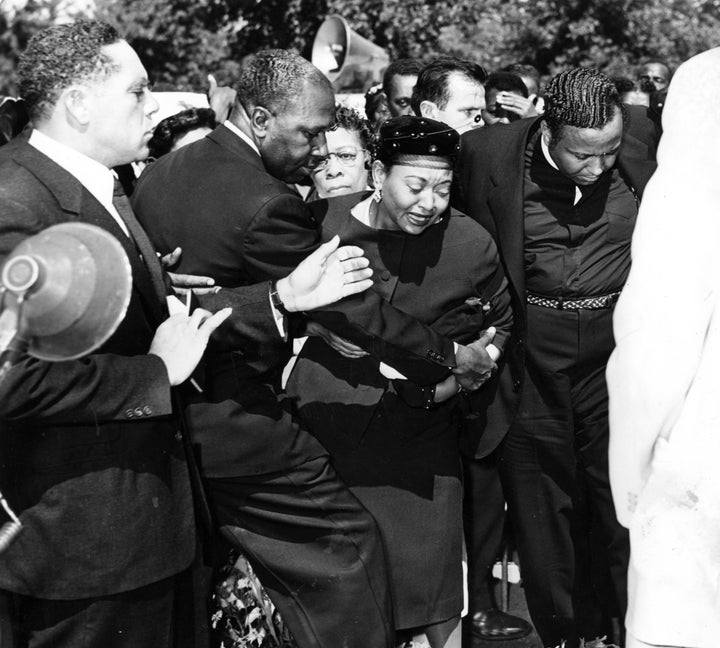 Mrs Mamie Bradley (center) reacts as the body of her son, Emmett Till, is lowered into his grave during the funeral, September 1955.