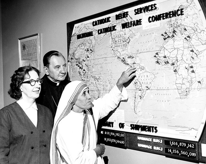 Eileen Egan and then CRS executive director Bishop Edward Swanstrom stand behind Mother Teresa.