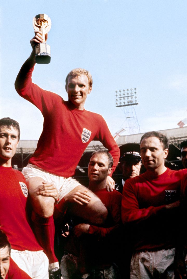 England captain Bobby Moore displays the World Cup trophy whilst being carried by his England colleagues after their 4-2 win against West Germany.