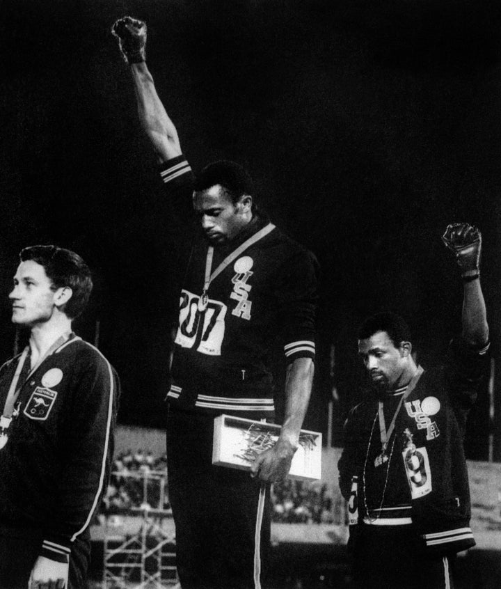 U.S. athletes Tommie Smith (C) and John Carlos (R) raise their gloved fists in solidarity with human rights to express their opposition to racism in the U.S. during the U.S. national anthem, after receiving their medals on Oct. 17, 1968, for first and third place in the men's 200m event at the Mexico Olympic Games. At left is Peter Norman of Australia, who took second place.