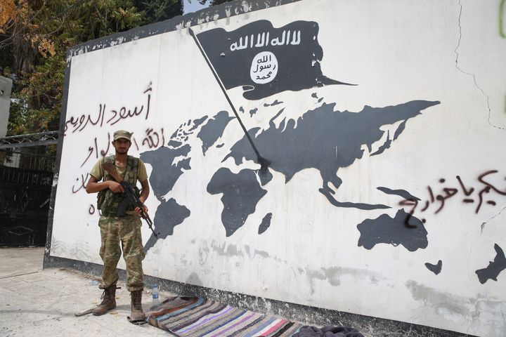 Soldiers write with a spray paint on a wall in support of Free Syrian Army in Jarabulus District of Aleppo