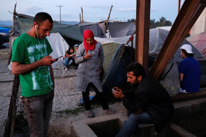 People use their mobile phones near a Wi-Fi hotspot at a makeshift camp for refugees and migrants near Idomeni, Greece, May 14, 2016.