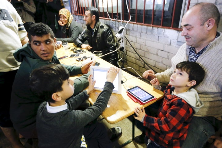 Migrants charge their mobile devices in a shelter for migrants inside a hangar of the former Tempelhof airport in Berlin, Germany, December 9, 2015.