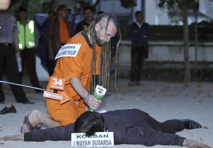 Dressed in an orange prison overall, David Taylor re-enacts the events which led to the death of police officer Wayan Sudarsa on a Bali beach last week