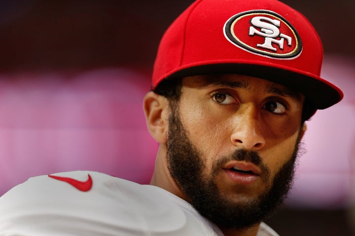 Colin Kaepernick watches from the sidelines during an NFL game against the Arizona Cardinals at the University of Phoenix Stadium.