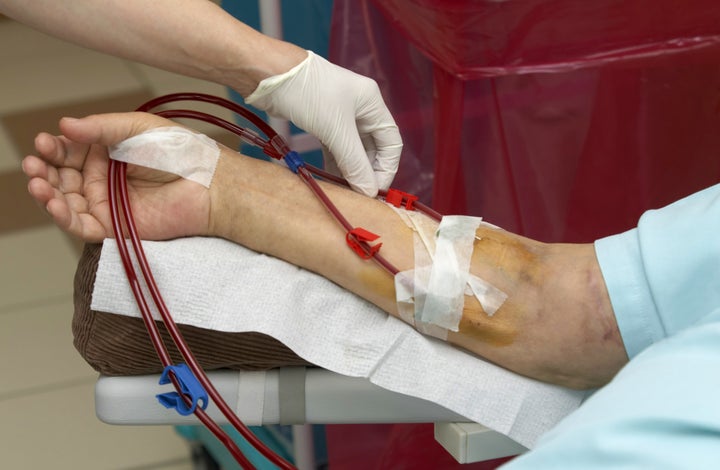 Patient being helped during dialysis session in hospital.