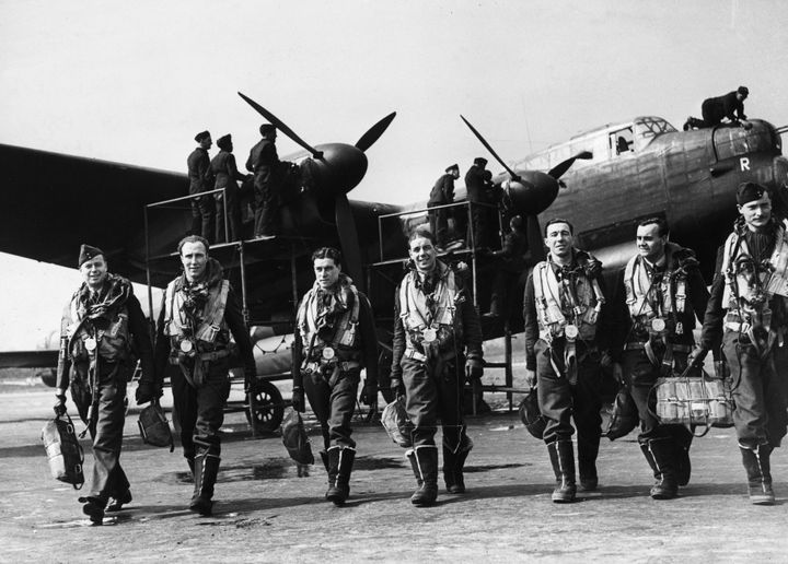 April 1943: The crew of a Lancaster bomber walk away from their plane after a flight while ground crew check it over.