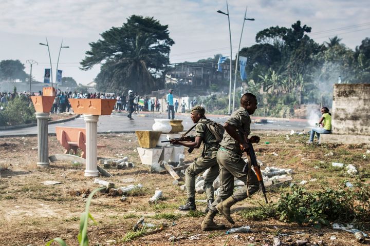 Gabonese soldiers run to take position as supporters of opposition leader Jean Ping protest in front of security forces blocking a demonstration trying to reach the electoral commission in Libreville on August 31, 2016.