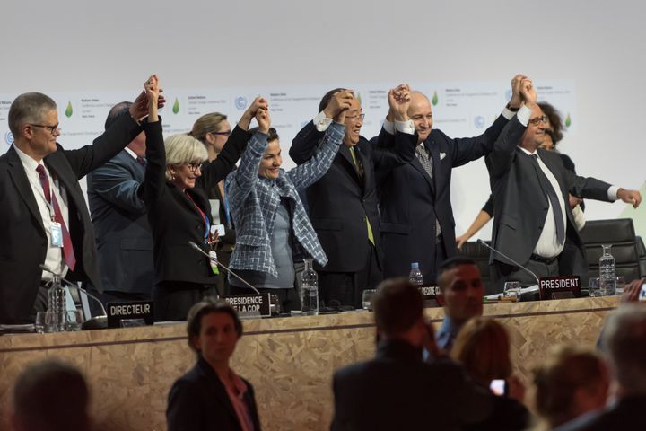 World leaders celebrate after the adoption of a historic global warming pact at the COP21 Climate Conference in Paris.
