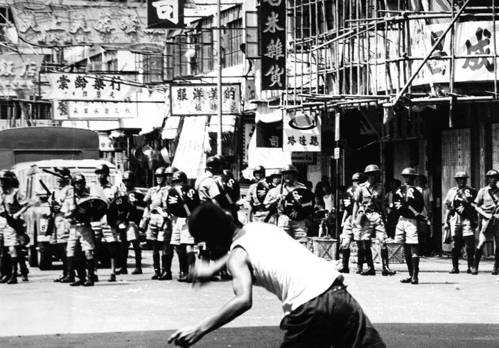 A rioter hurls a rock at police patrol during riots in Hong Kong, May 1967.