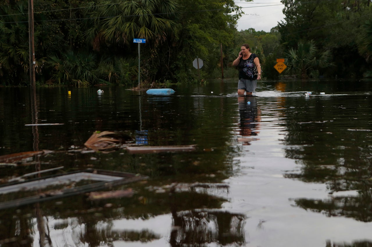 Lynne Garrett speaks to loved ones on the phone as she surveys damage outside of her home from the winds and storm surge associated with Hurricane Hermine which made landfall overnight in the area on September 2, 2016 in Tampa, Florida.