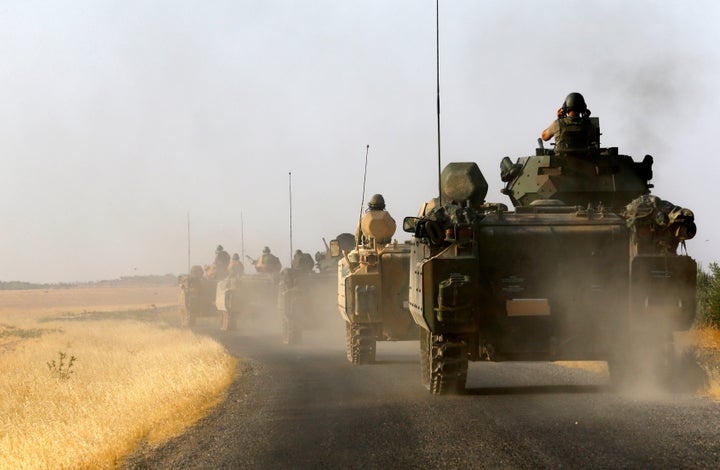 Turkish armoured personnel carriers are driven towards the border in Karkamis on the Turkish-Syrian border in the southeaster