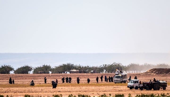 Syrian people run away from clashes between Turkish soldiers and Islamic State group fighters, 20 km west of the Turkish-Syri