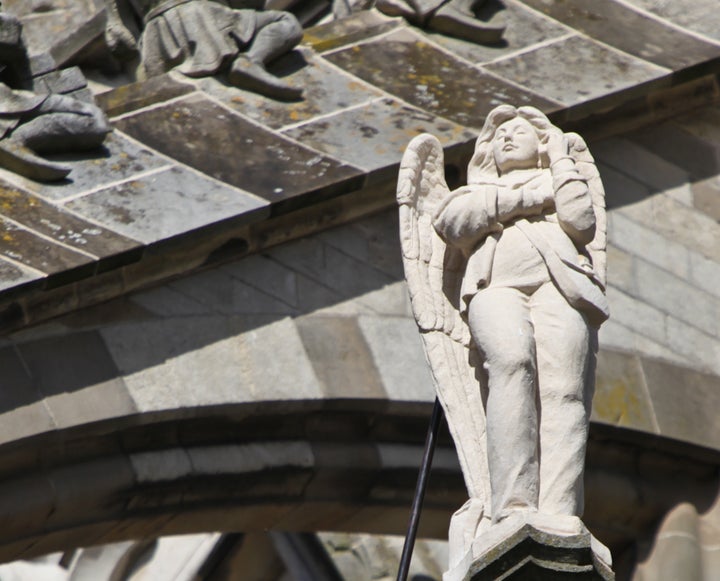 An angel on his/her cell phone on one of the flying buttresses of St John's Cathedral, Den Bosch, Netherlands.
