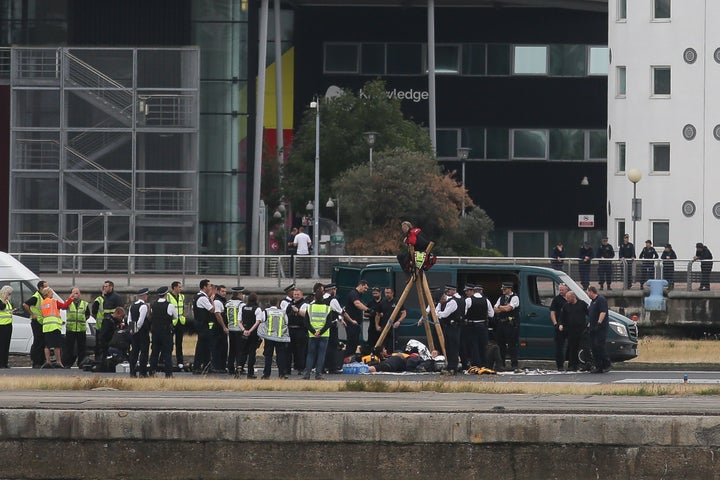 Emergency services surround protestors from the movement Black Lives Matter after they locked themselves to a tripod on the runway at London City Airport in London on Tuesday.