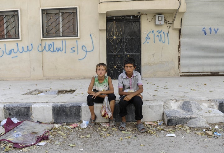 JARABLUS, SYRIA - AUGUST 31: Boys sit in front of their homes in the border town of Jarablus, August 31, 2016, Syria. Turkish troops and Turkey-backed rebels have been fighting Kurdish-led forces and IS since Turkey's incursion into Syria on Aug. 24. with the swift capture of Jarablus, a town a few km inside Syria that was held by Islamic State.