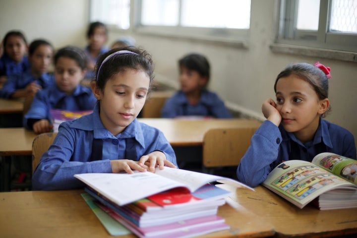 Refugee schoolchildren receive their new books on the first day of the new school year at one of the UNRWA schools at a Pales