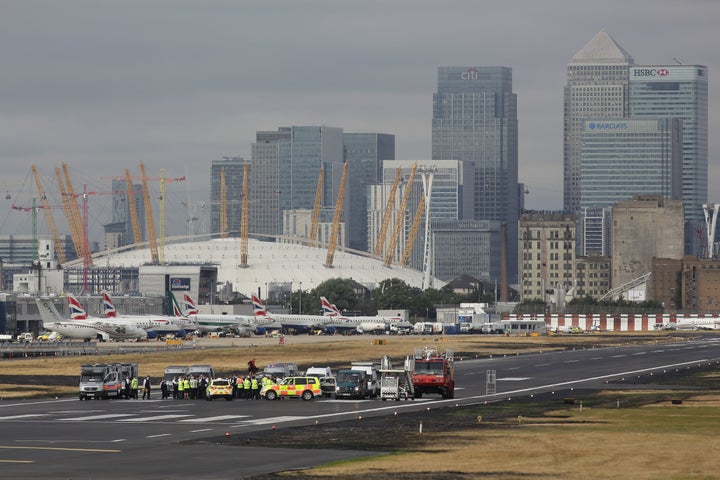 Emergency services surround protestors from the movement Black Lives Matter after they locked themselves to a tripod on the runway at London City Airport. 