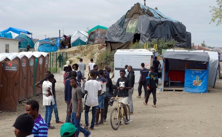 Migrants walk in the northern area of the camp called the "Jungle" in Calais, France