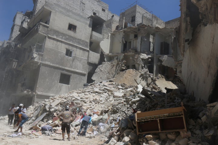 Residents inspect a damaged site after an airstrike on Aleppo's rebel-held al Mashad neighborhood in Syria on July 26.