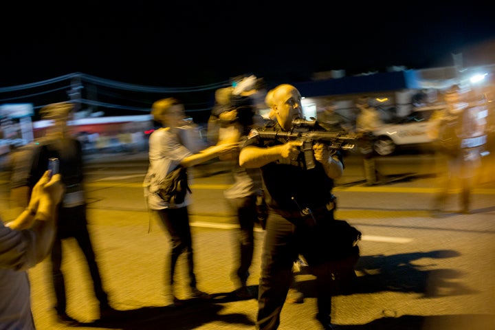 Lt. Ray Albers points his weapon at protesters on Aug. 19, 2014.