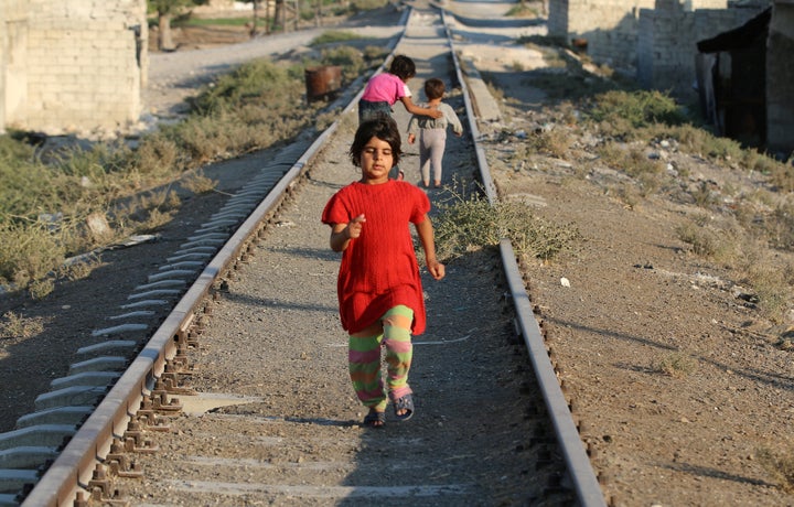 A girl walks along a broken railway track in a rebel-held neighborhood in Aleppo, Syria, on Sept. 1. The city was t