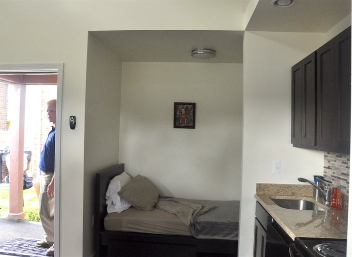 The interior of the first home built by Cass Community Social Services, showing the bed and kitchen in the small studio space.