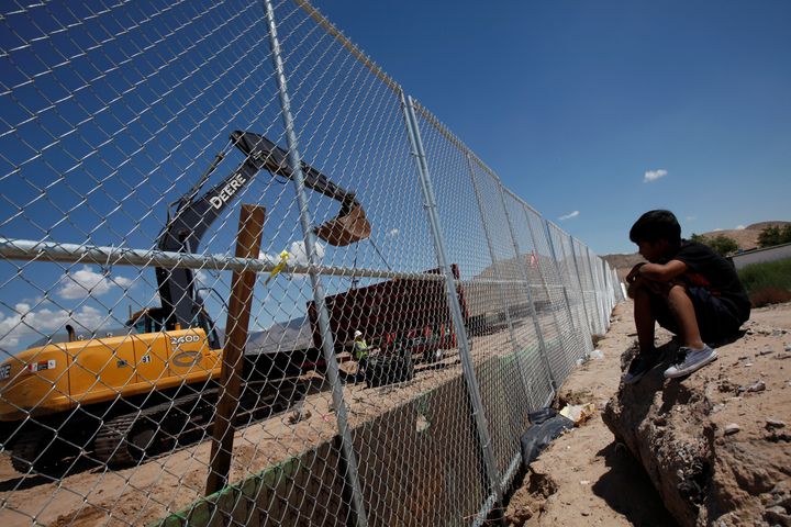 A child on the Mexican side of the border watches U.S. workers build a section of wall opposite Ciudad Juarez, Mexico, on Aug. 26, 2016.